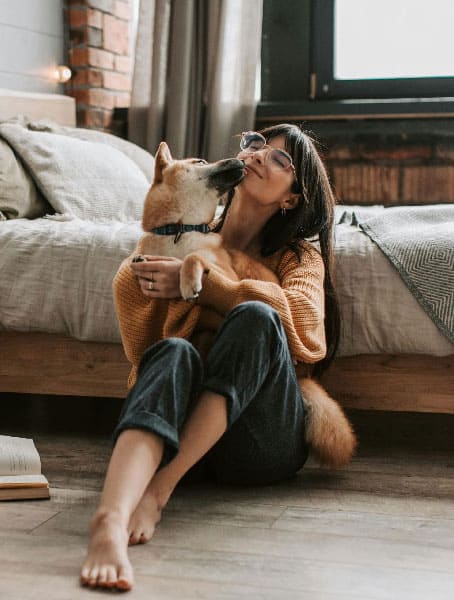 An image of a dog and a woman cuddling, after successful Miami dog training